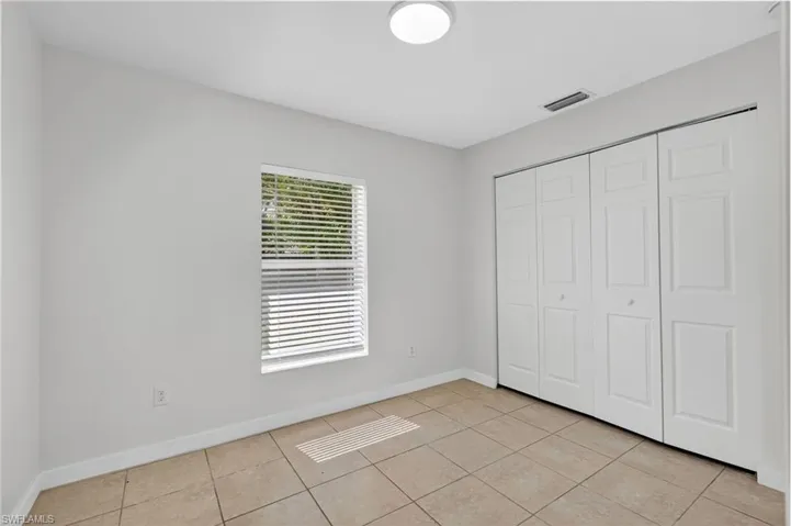 Unfurnished bedroom featuring light tile patterned floors and a closet