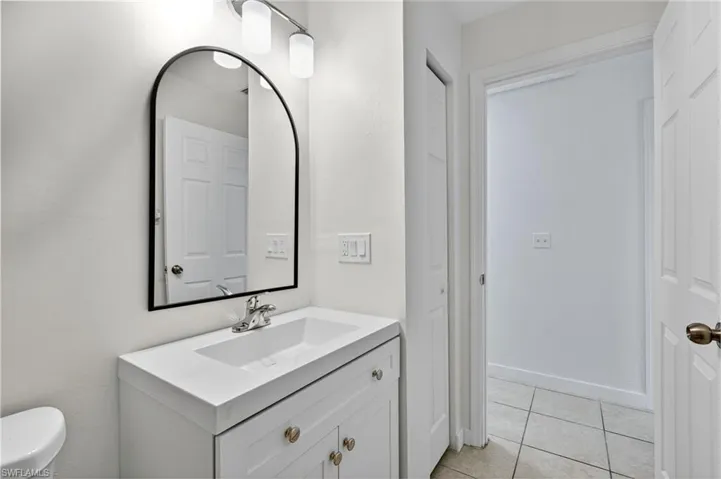 Bathroom with light tile patterned floors and vanity