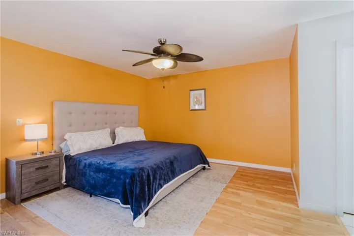 Bedroom featuring light wood-style flooring, a ceiling fan, and baseboards