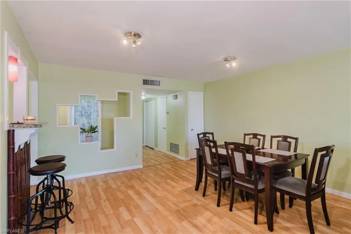 Dining area featuring visible vents, baseboards, and wood finished floors