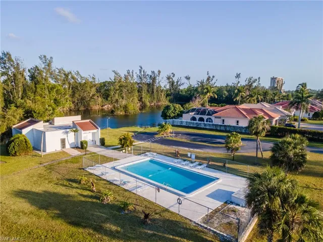 View of pool featuring a lawn, a water view, a fenced in pool, and fence