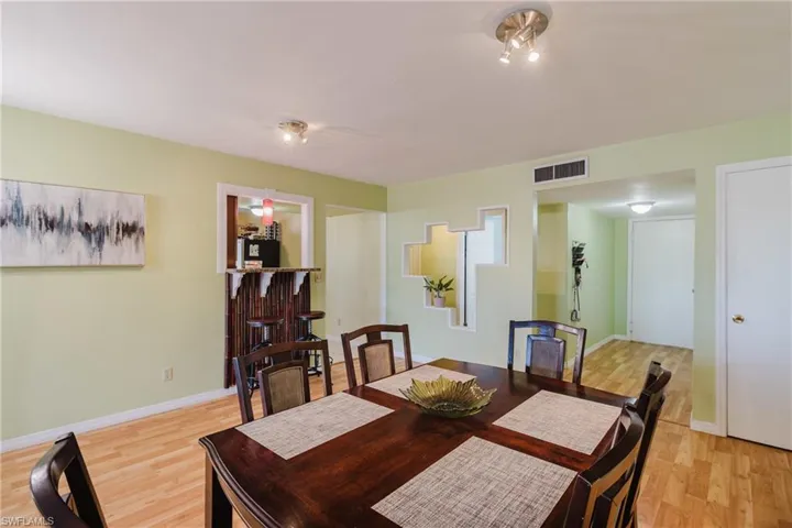 Dining space featuring visible vents, baseboards, and wood finished floors