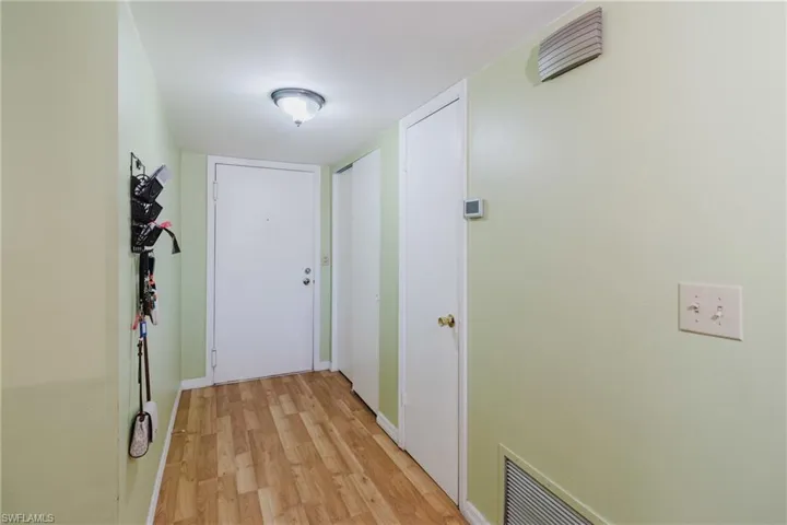 Doorway with visible vents, baseboards, and light wood-style flooring