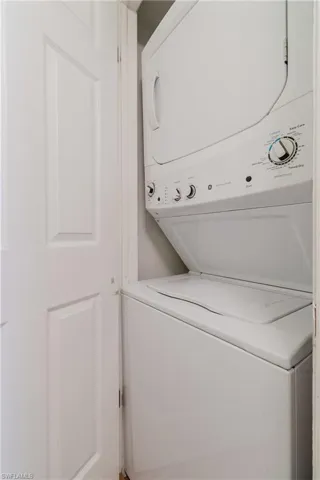 Washroom featuring stacked washer / dryer and laundry area