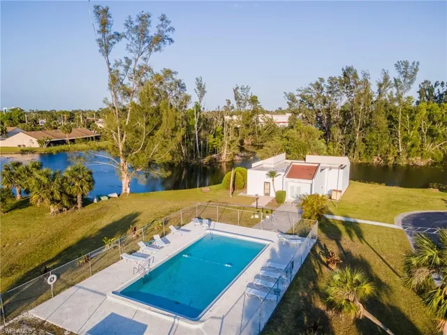 Community pool featuring a lawn, a patio, a fenced backyard, and a water view