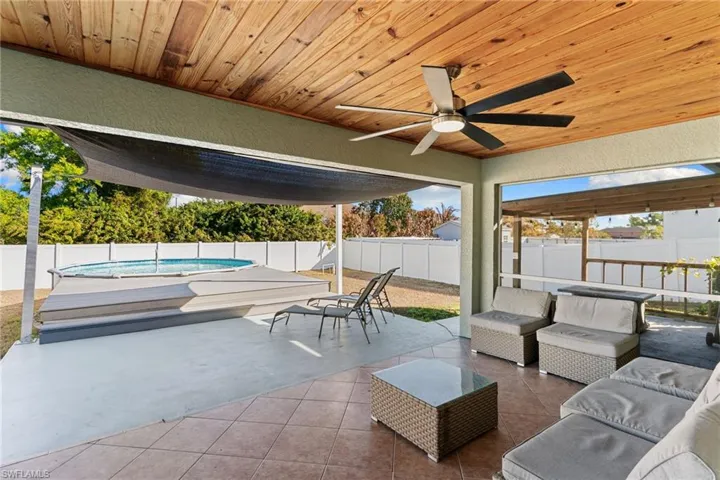 Fenced backyard featuring an outdoor lounge area, ceiling fan, and a patio