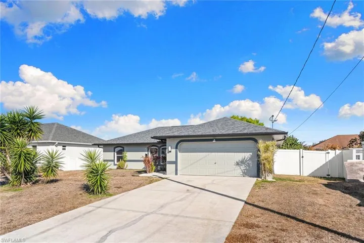 Ranch-style home with a gate, driveway, a garage, and stucco siding