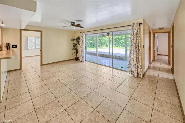 Empty room with light tile patterned floors and ceiling fan