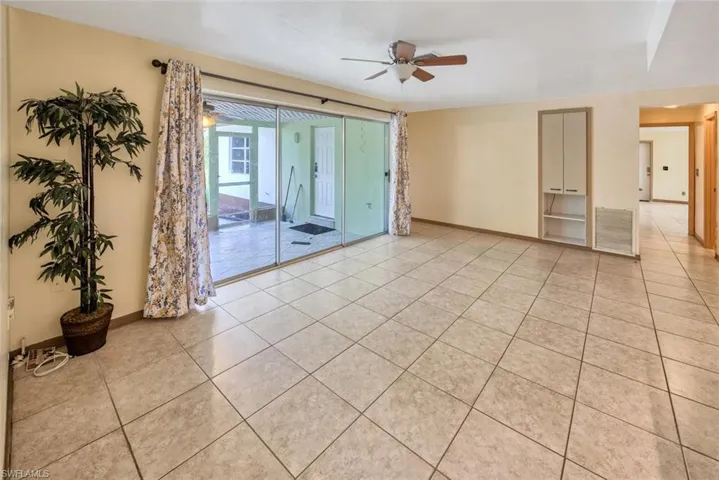 Unfurnished room with light tile patterned flooring and ceiling fan