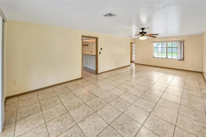 Unfurnished room with light tile patterned floors and ceiling fan