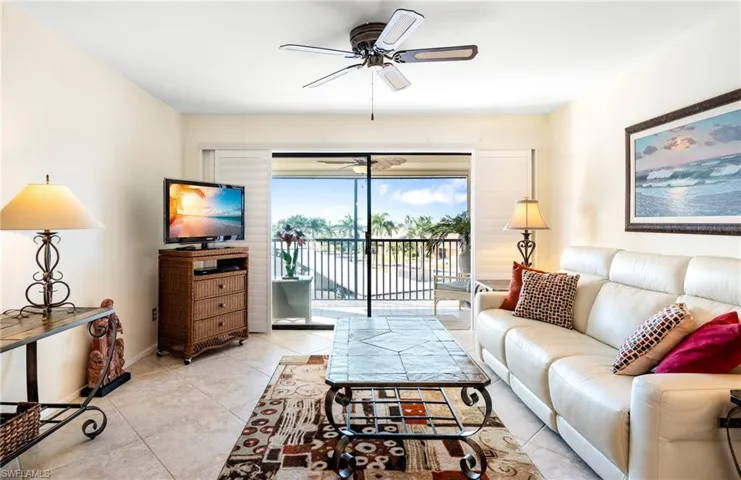 Living area featuring ceiling fan and light tile patterned flooring
