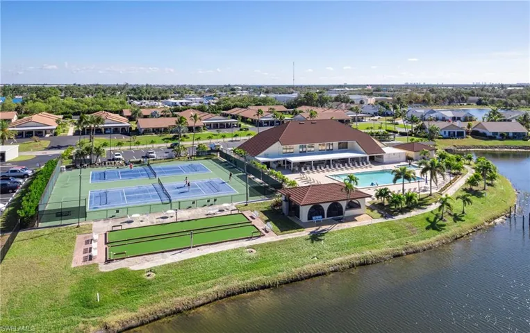 Aerial perspective of suburban area featuring a pool area and a large body of water