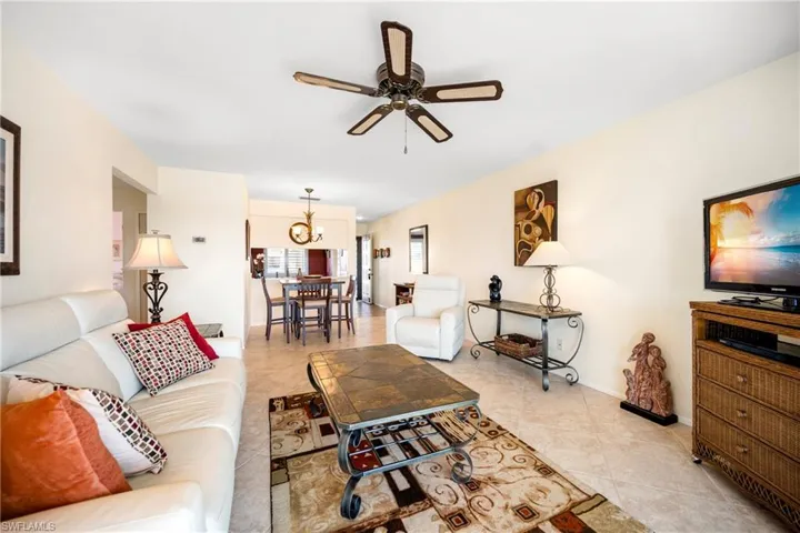 Living room with ceiling fan, a chandelier, and light tile patterned floors