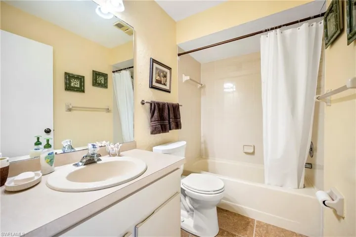 Full bathroom with vanity, shower / tub combo, and light tile patterned floors