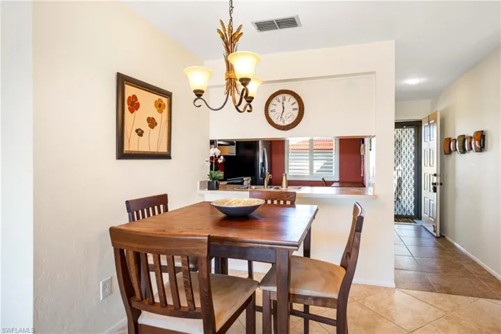 Dining room with suspended lighting and light tile patterned floors