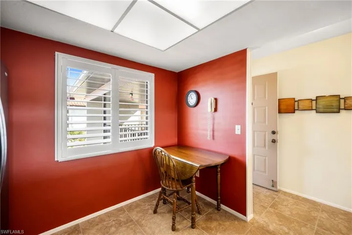 Kitchenette by window with tile floor.