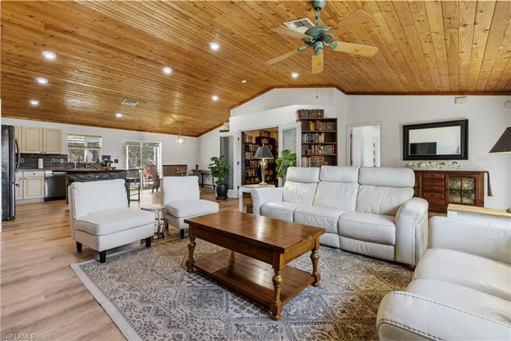Living room with a ceiling fan, a high wooden ceiling, light wood-style floors, and recessed lighting