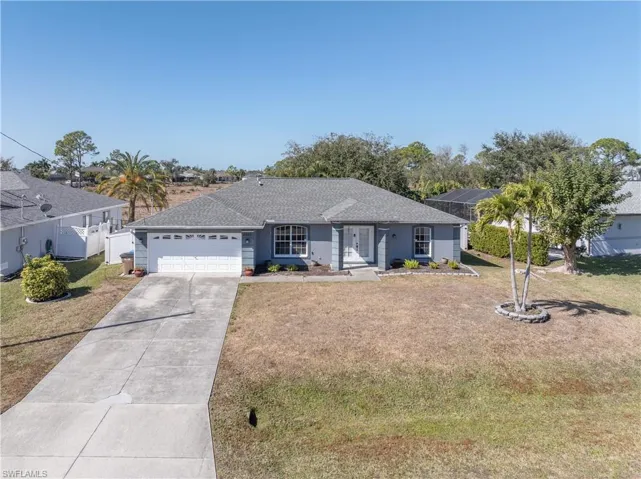 Ranch-style house featuring driveway, a garage, and a shingled roof