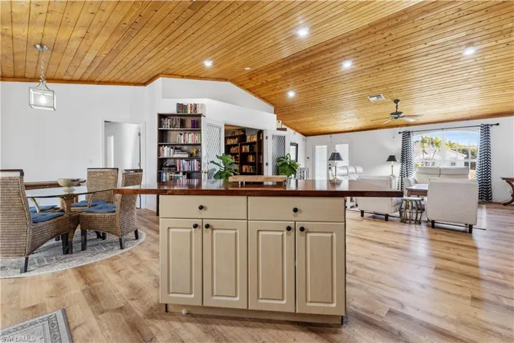 Kitchen featuring a vaulted wooden ceiling, pendant lighting, a ceiling fan, light wood-style floors, and a kitchen island