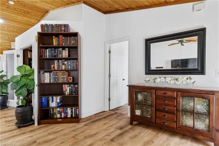 Living area featuring a vaulted wooden ceiling, light wood-type flooring, and ceiling fan