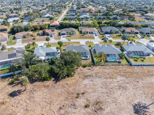 Aerial view of property and surrounding area featuring nearby suburban area