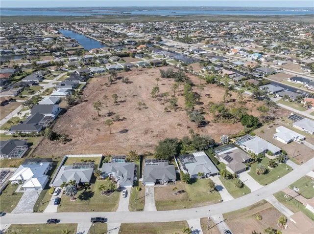 Aerial view of property's location with nearby suburban area and a large body of water