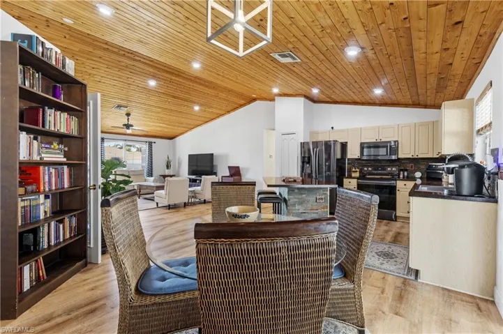 Dining area with ceiling fan, a vaulted wooden ceiling, light wood finished floors, and recessed lighting