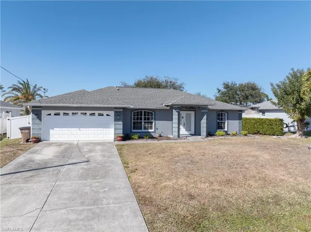 Ranch-style house featuring roof with shingles, driveway, and an attached garage