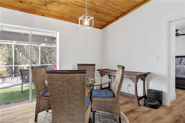Dining area with light wood-style flooring and a vaulted wood ceiling