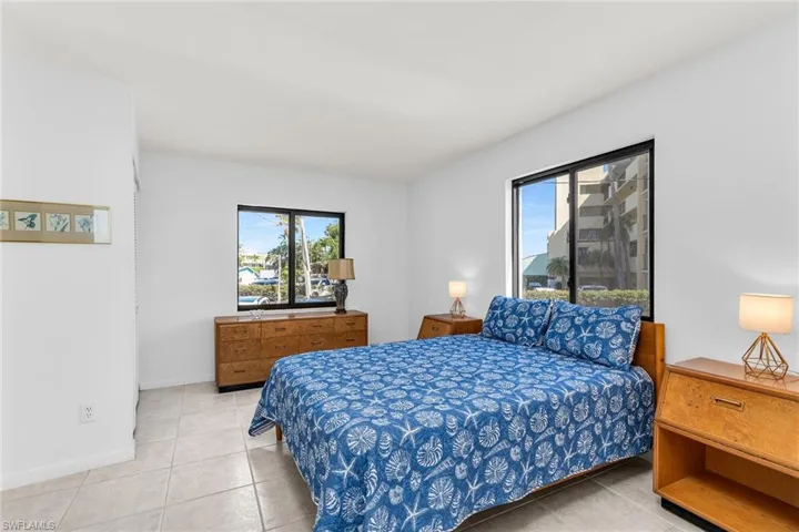 Bedroom with light tile patterned flooring and baseboards