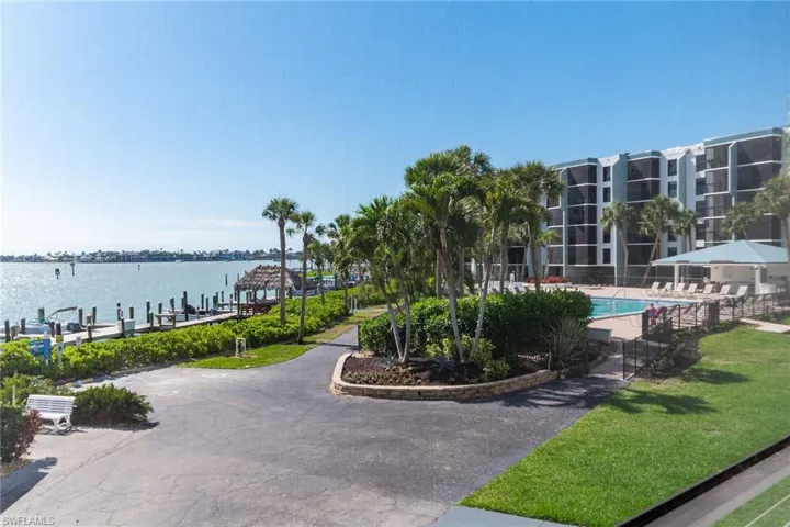 View of property's community with a water view, a swimming pool, and a dock