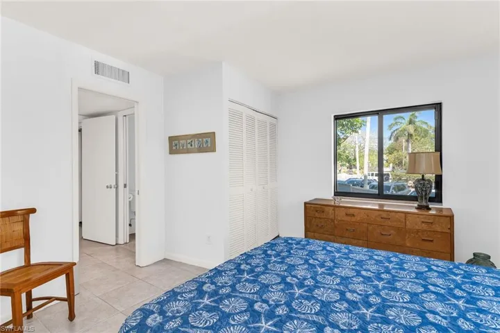 Bedroom featuring light tile patterned floors, visible vents, a closet, and baseboards