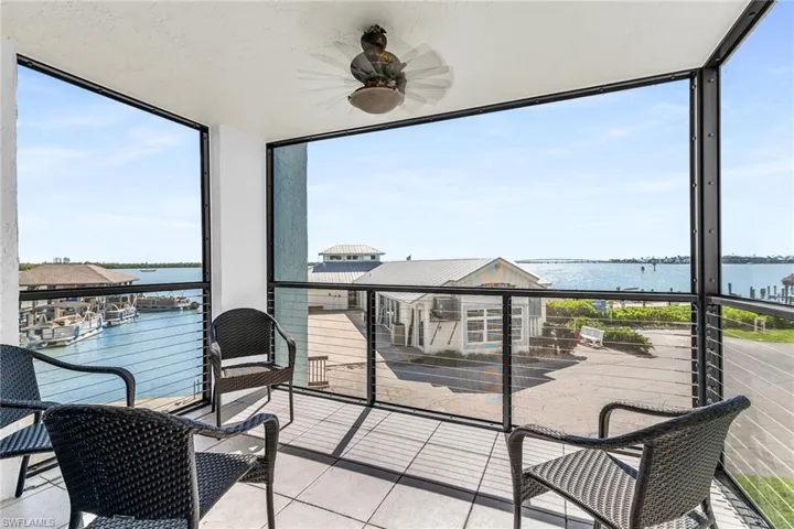 Sunroom / solarium with a water view and ceiling fan