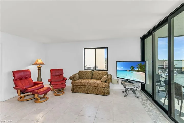 Living room featuring light tile patterned floors, baseboards, and floor to ceiling windows