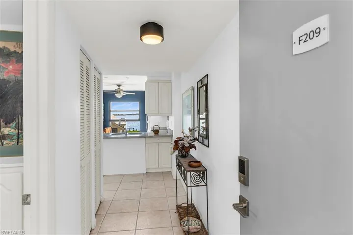 Hallway with a sink and light tile patterned flooring
