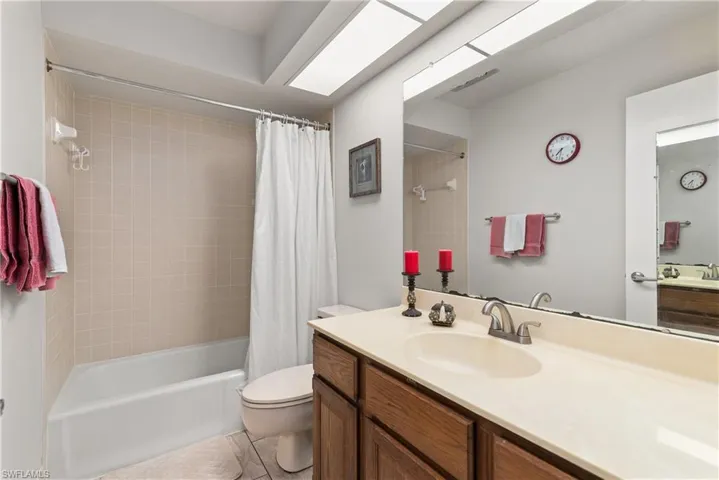 Bathroom featuring vanity, shower / bath combo with shower curtain, and light tile patterned floors