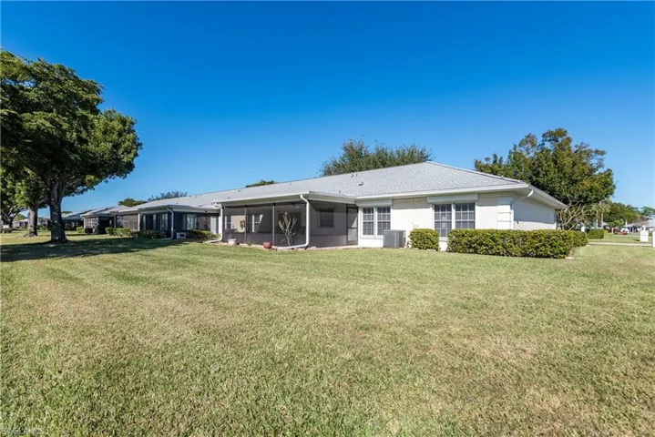 Back of house featuring a lawn and a sunroom