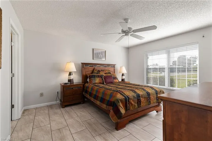 Bedroom featuring a ceiling fan and a textured ceiling