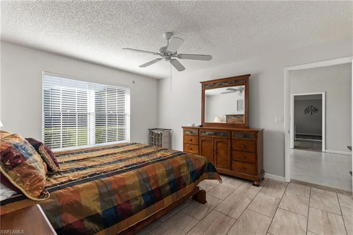 Bedroom with a textured ceiling and ceiling fan