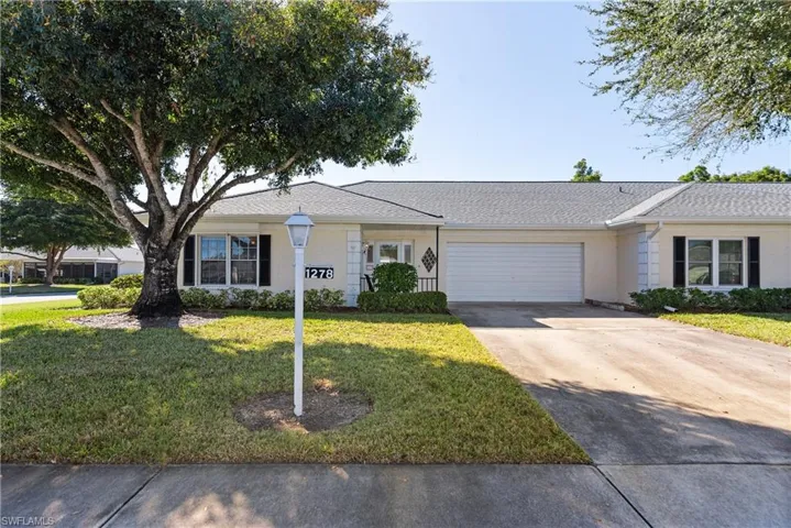 Single story home with driveway, a front yard, a shingled roof, a garage, and stucco siding