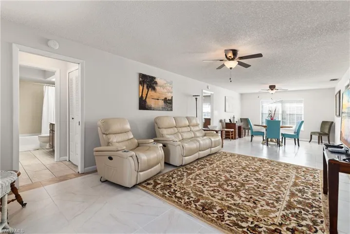 Living area with ceiling fan and a textured ceiling
