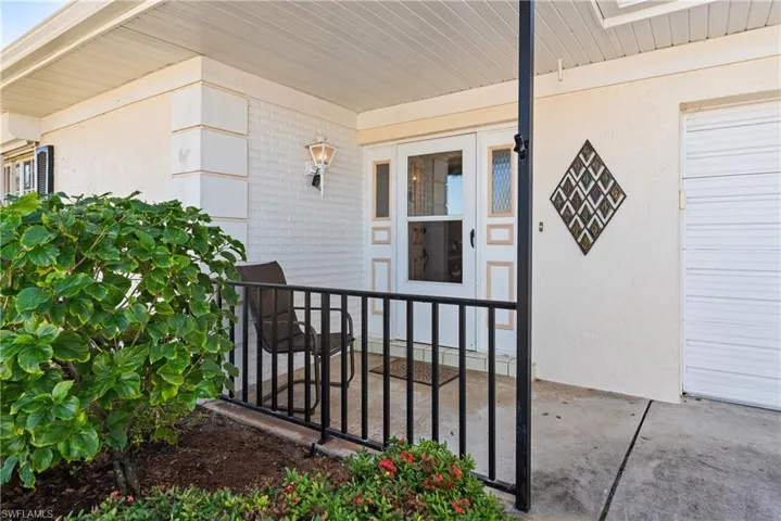 View of exterior entry featuring stucco siding, brick siding, and covered porch