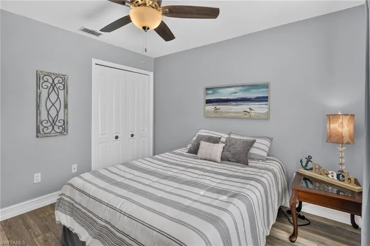 Wood-finish flooring, ceiling fan with integrated lighting, and double-door closet