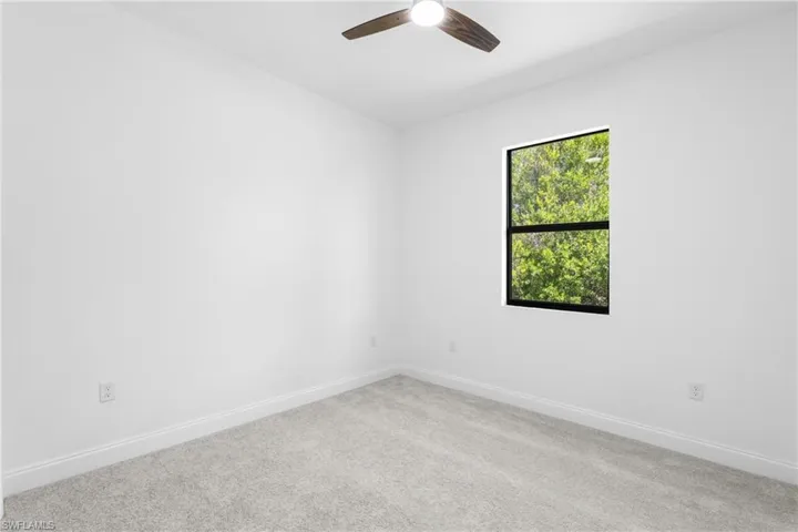 Empty room featuring carpet and a ceiling fan