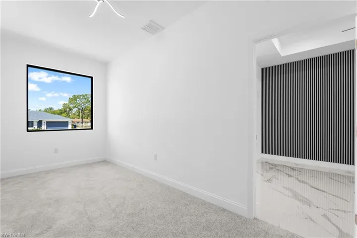 Spare room featuring carpet flooring and baseboards