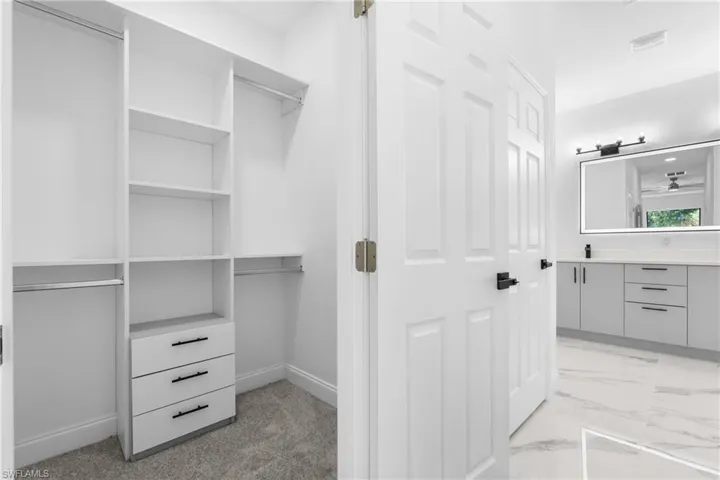 Walk in closet with light marble finish flooring