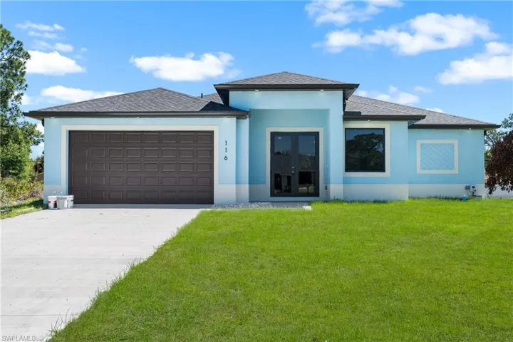 Prairie-style home featuring french doors, a garage, stucco siding, concrete driveway, and a front yard
