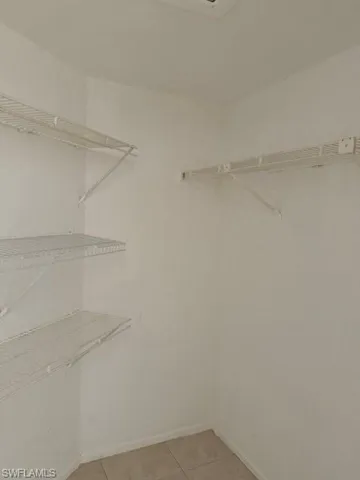 Spacious closet featuring light tile patterned flooring