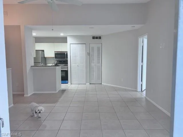 Kitchen featuring white cabinetry, stainless steel appliances, recessed lighting, light tile patterned floors, and a peninsula
