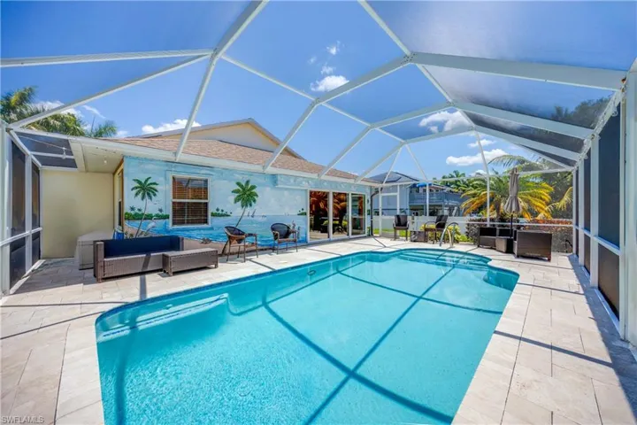 View of heated swimming pool with large screened in lanai and travertine pavers with lots of space to entertain